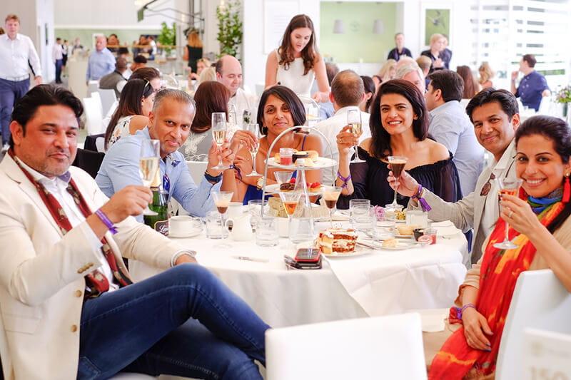 Guests on a table in The Lawn at Wimbledon enjoying a drink and their lunch served by two Michelin Star chef Michel Roux Jr 